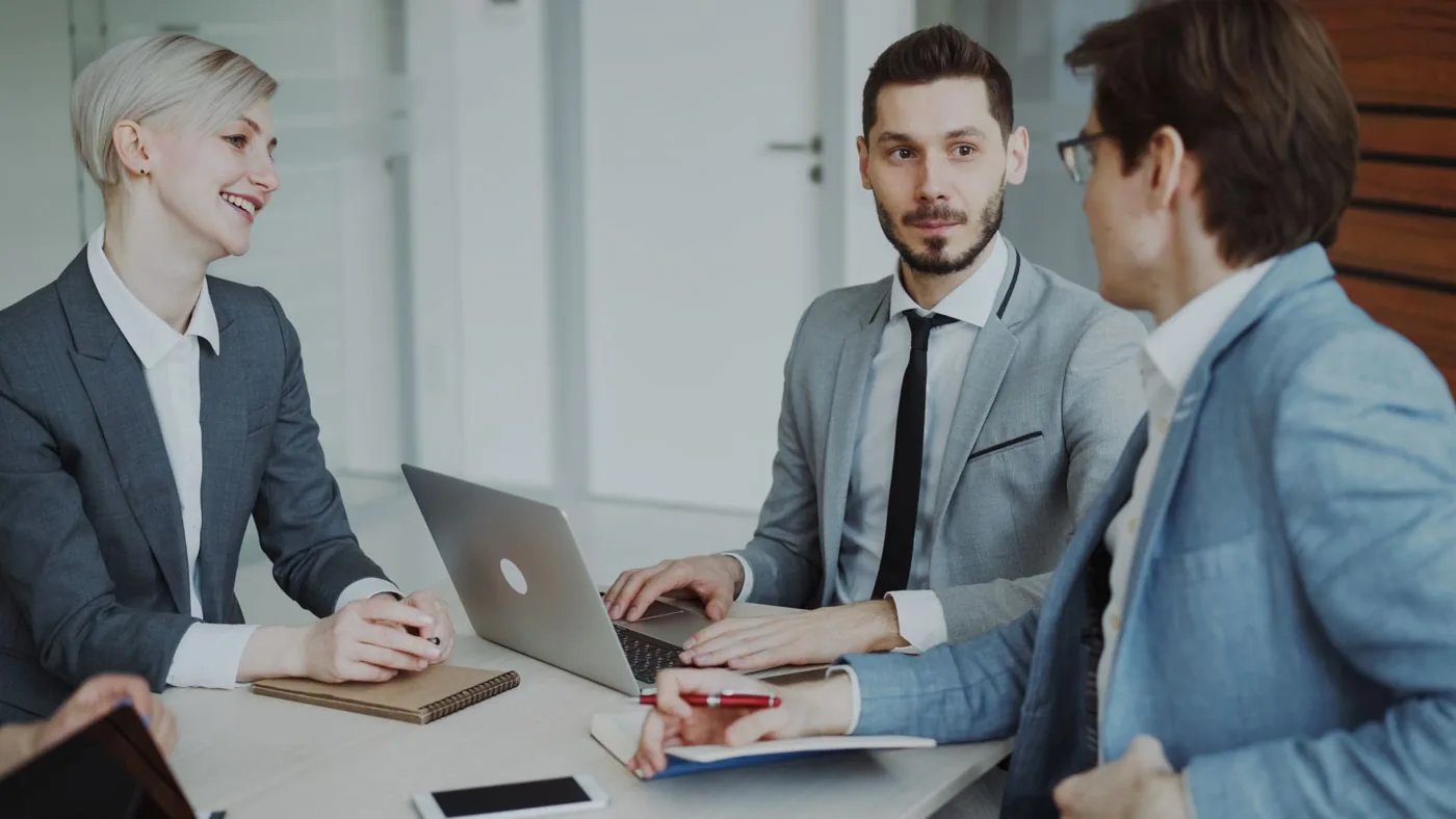 Small business team discussing outsourcing versus in-house SEO decision