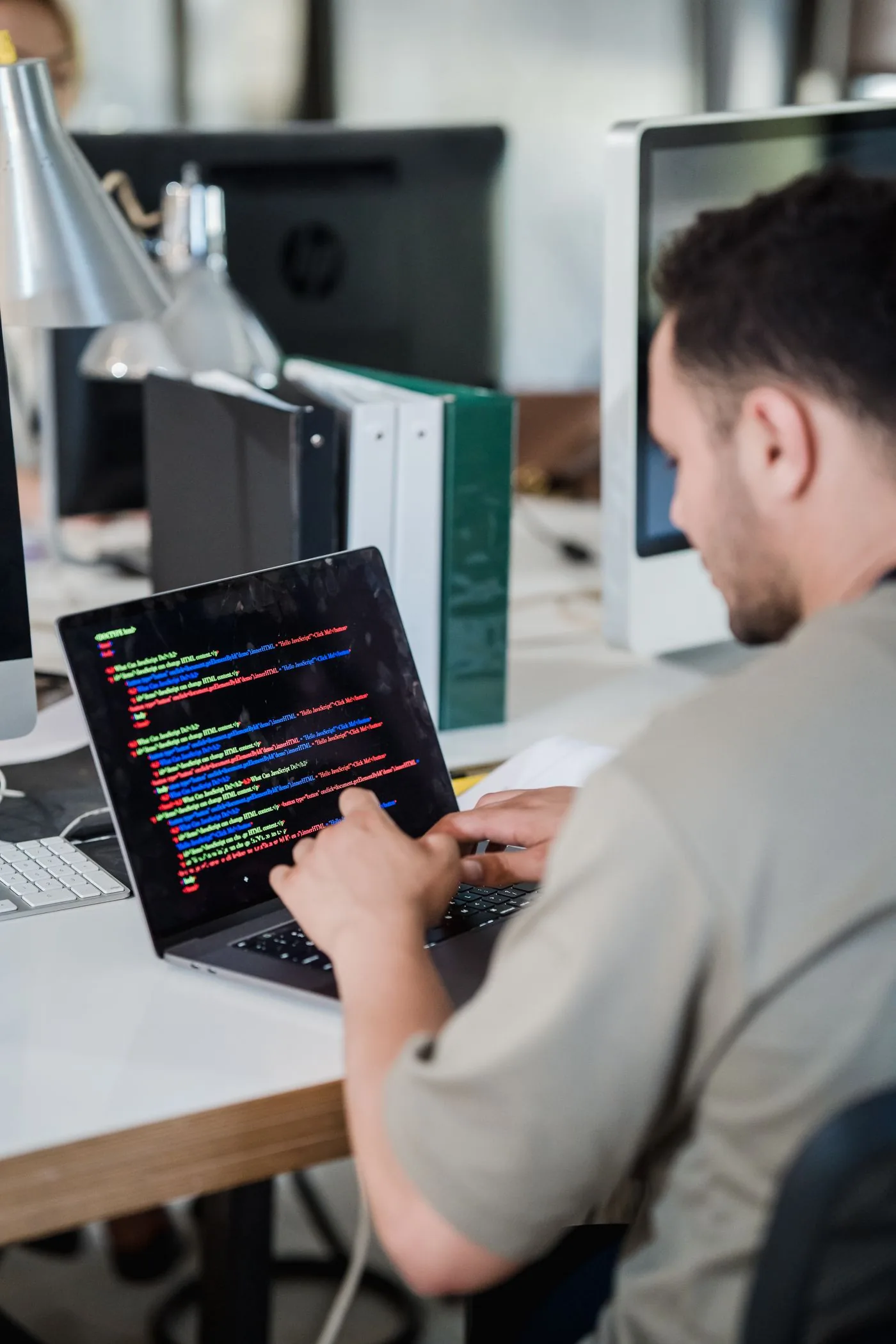 Professional working on a website redesign with code and design tools in a modern office
