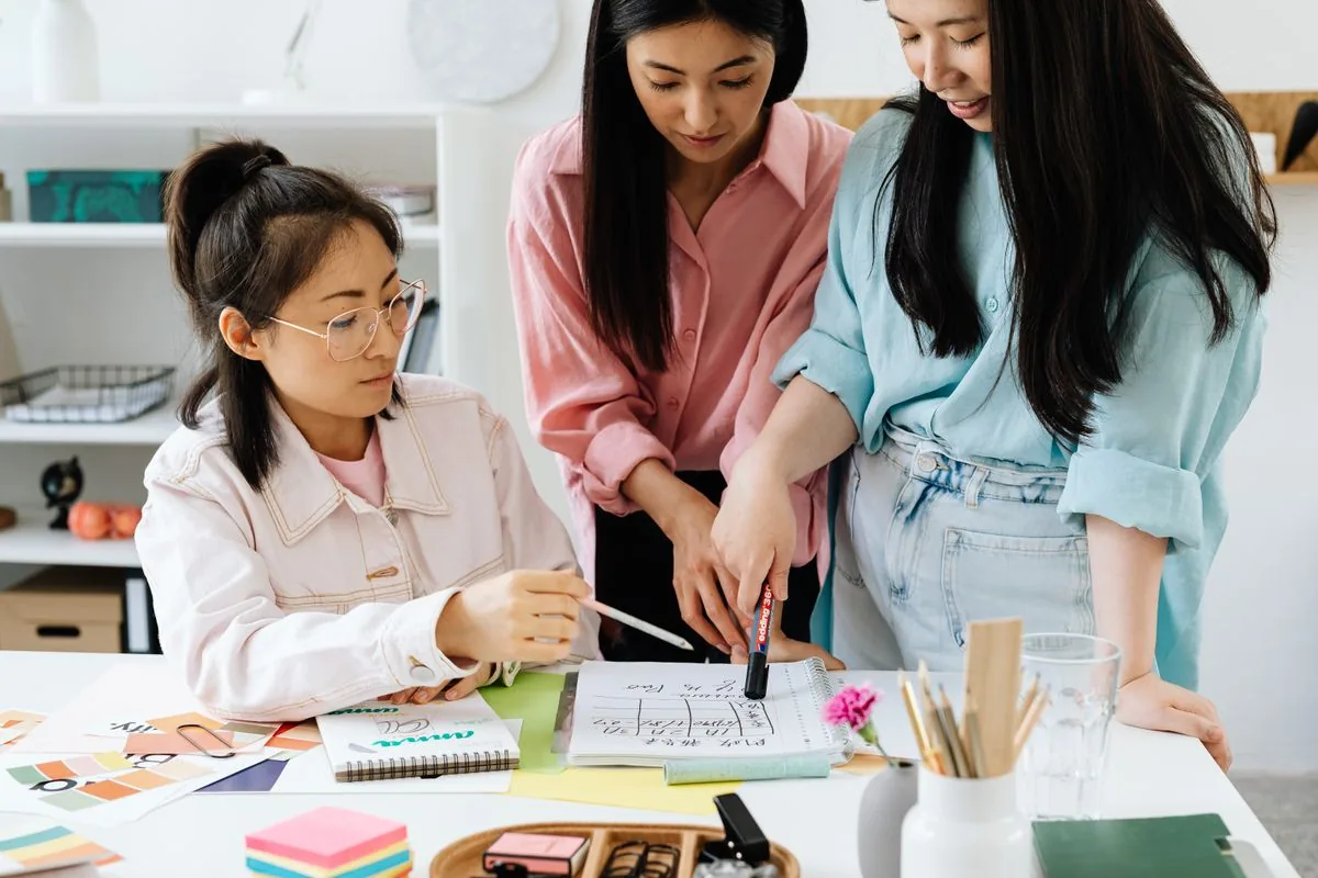 Web design team in Singapore reviewing colour palettes and wireframe sketches during the design phase of a website project