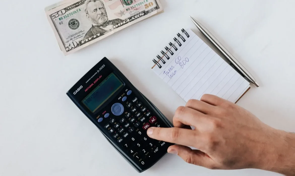 Calculator, budget documents and a laptop on a desk