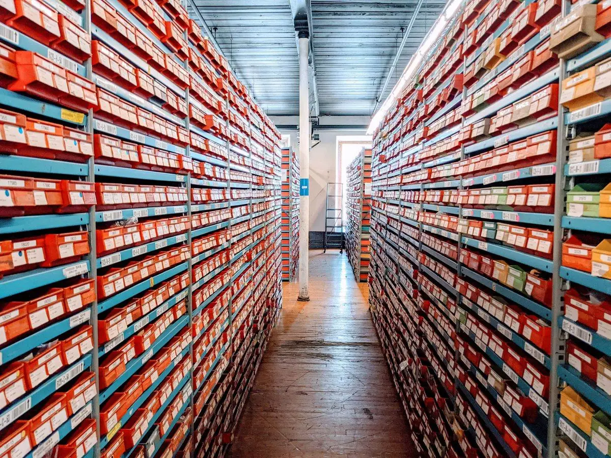 Warehouse aisle lined with thousands of individually labelled stock boxes