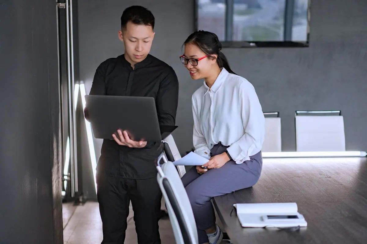 Two colleagues scoping an SEO programme together on a laptop